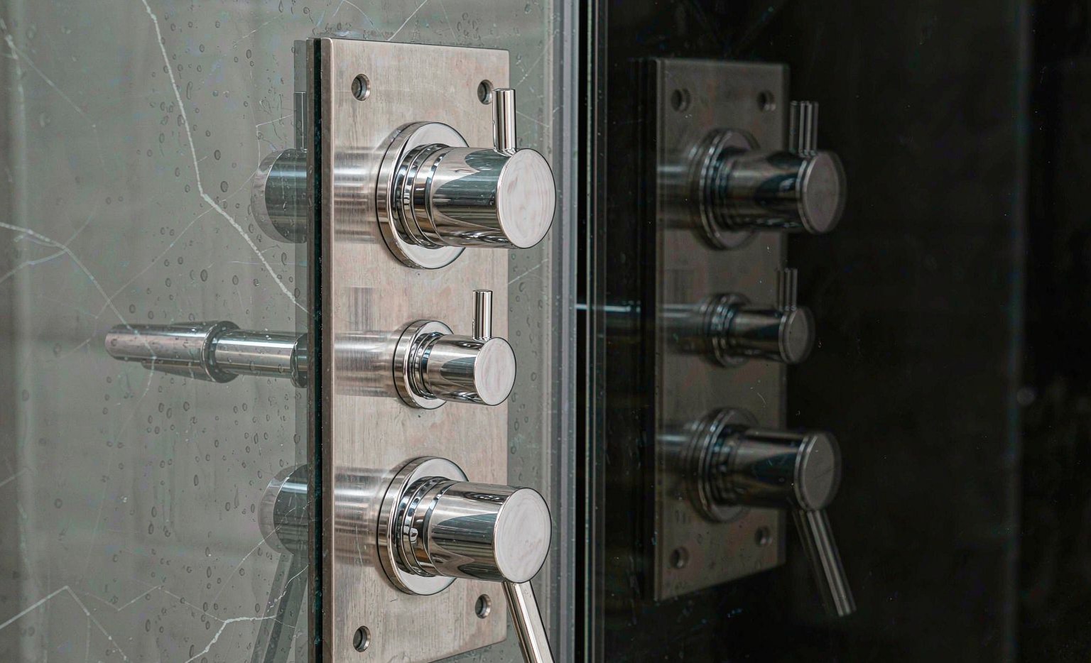 Brushed stainless shower hardware against glass