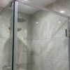 Frameless shower door in tempered glass on a tiled wall