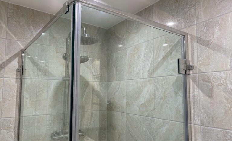 Frameless shower door in tempered glass on a tiled wall