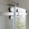 Stainless steel rollers on the top rail of a frameless sliding shower door
